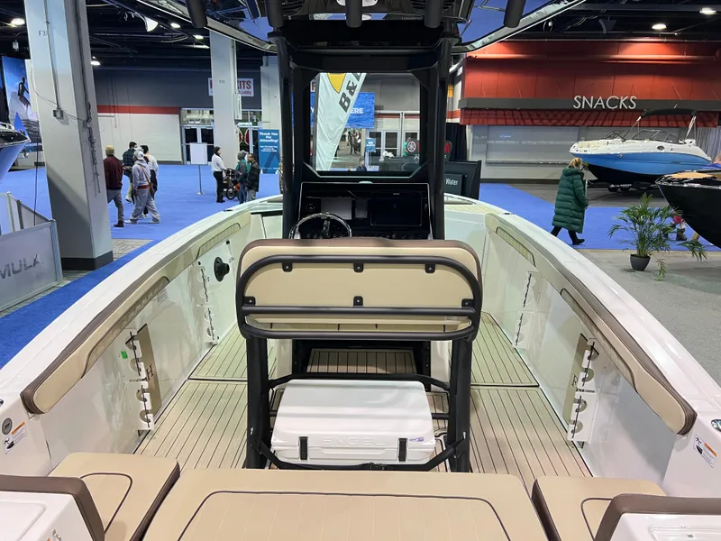 Slide: The Image of 2025 Yamaha Boats 255 FSH Sport H interior at a boat show, featuring sleek design and seating. - 3
