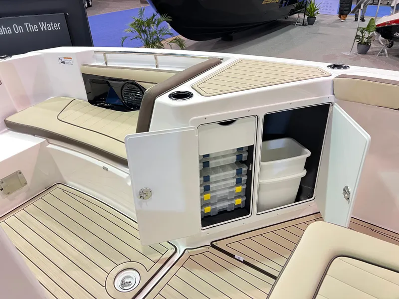 Slide: The Image of 2025 Yamaha Boats 255 FSH Sport H interior storage and seating area. - 7