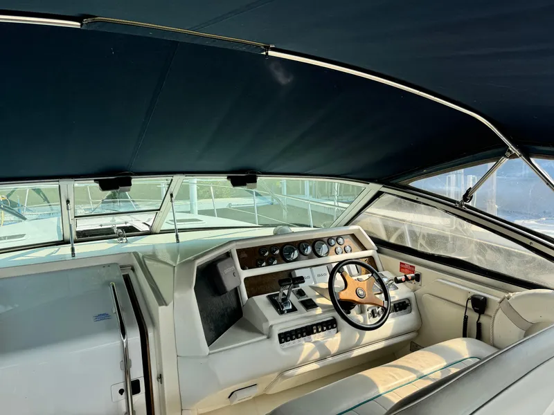 Slide: The Image of 1995 Sea Ray 370 Express Cruiser helm with steering wheel and instrument panel under canopy. - 11