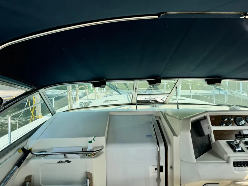 Slide: The Image of 1995 Sea Ray 370 Express Cruiser helm with covered dashboard and steering controls. - 12