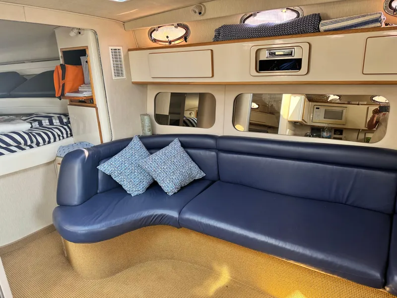 Slide: The Image of Interior of 1995 Sea Ray 370 Express Cruiser with blue seating and cozy cabin features. - 18