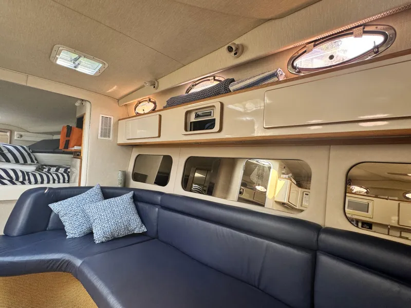 Slide: The Image of Interior of 1995 Sea Ray 370 Express Cruiser with blue seating and decorative pillows. - 22