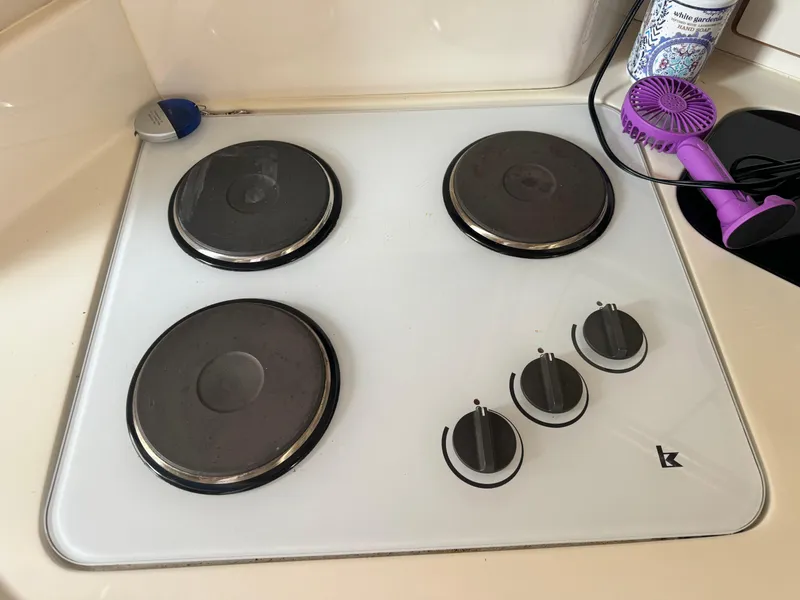 Slide: The Image of Stovetop with four burners and control knobs on a 1995 Sea Ray 370 Express Cruiser. - 25