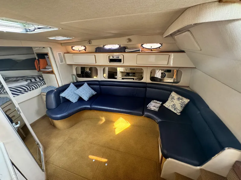 Slide: The Image of Interior of 1995 Sea Ray 370 Express Cruiser with blue seating and cozy decor. - 26
