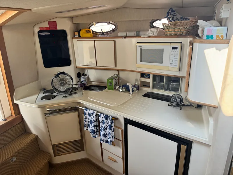 Slide: The Image of Interior of 1995 Sea Ray 370 Express Cruiser kitchen with appliances and storage. - 27