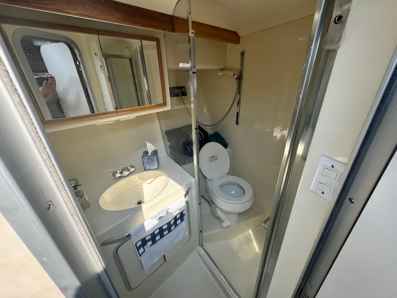 Slide: The Image of Bathroom interior of 1995 Sea Ray 370 Express Cruiser with sink, mirror, and toilet. - 29