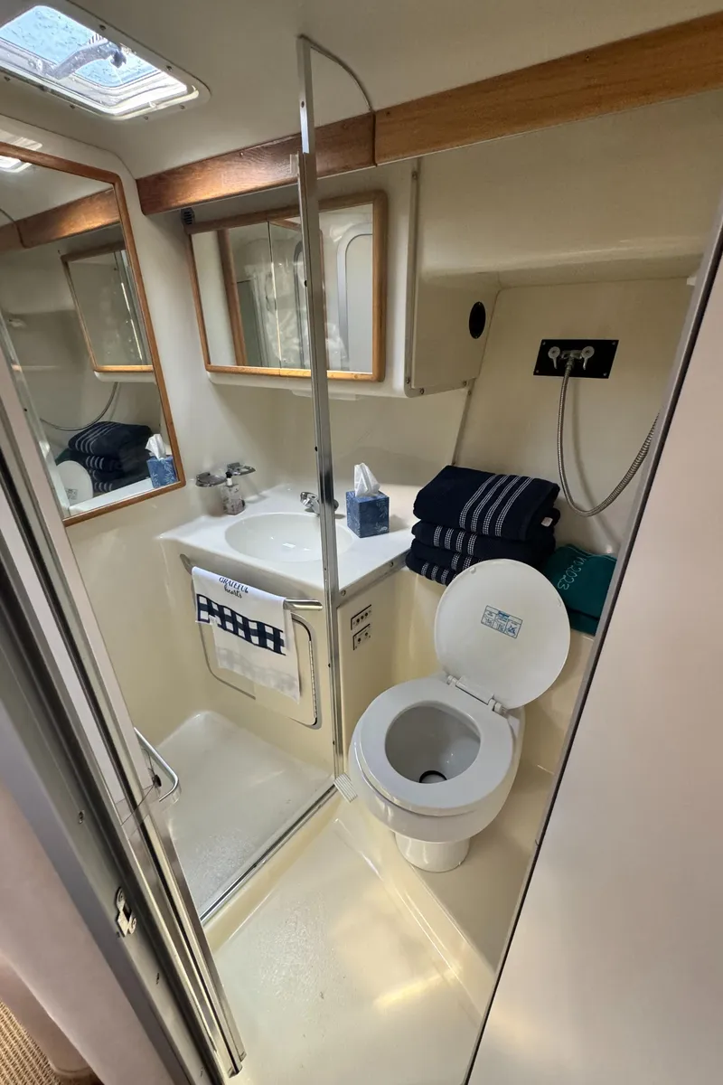 Slide: The Image of 1995 Sea Ray 370 Express Cruiser bathroom with sink, toilet, and mirror. - 31