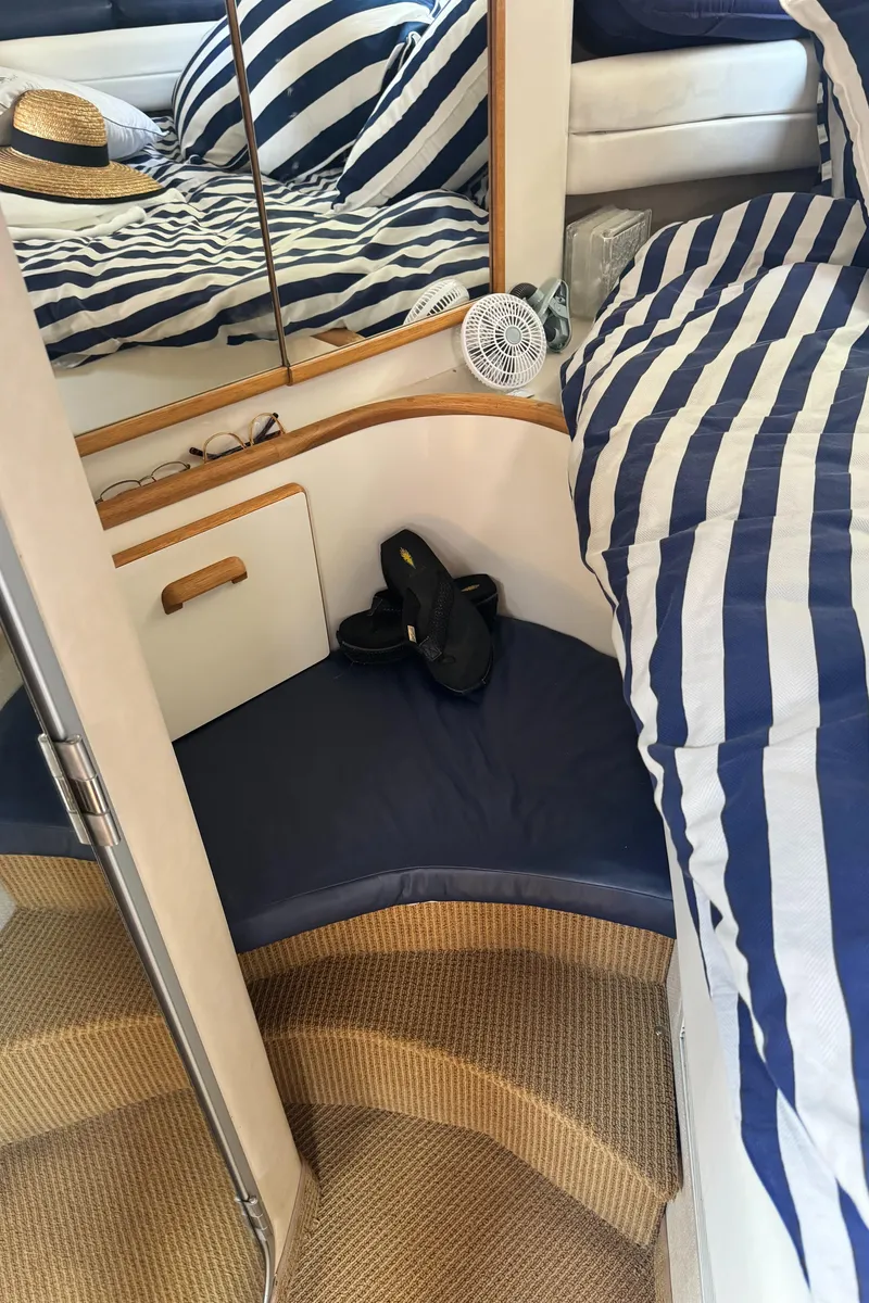 Slide: The Image of Interior of 1995 Sea Ray 370 Express Cruiser with striped bedding and nautical decor. - 33