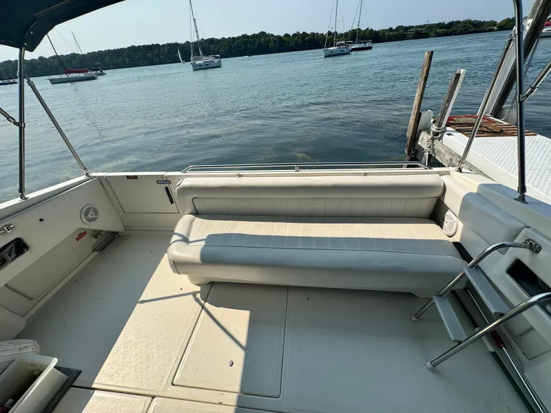 Slide: The Image of 1995 Sea Ray 370 Express Cruiser interior with seating, docked by a serene lake. - 4