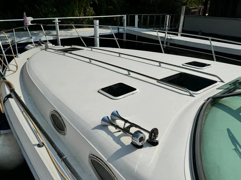 Slide: The Image of 1995 Sea Ray 370 Express Cruiser boat deck with railings and windows. - 7