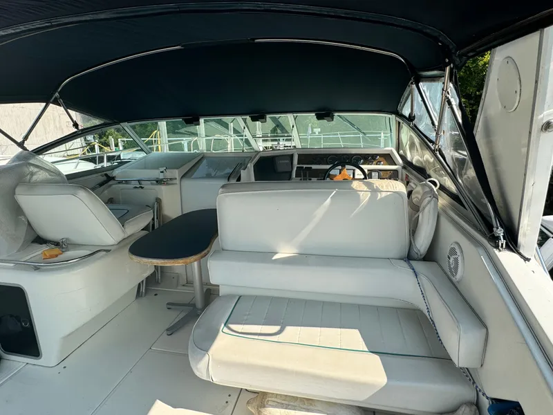 Slide: The Image of 1995 Sea Ray 370 Express Cruiser interior with seating and helm under canopy. - 8