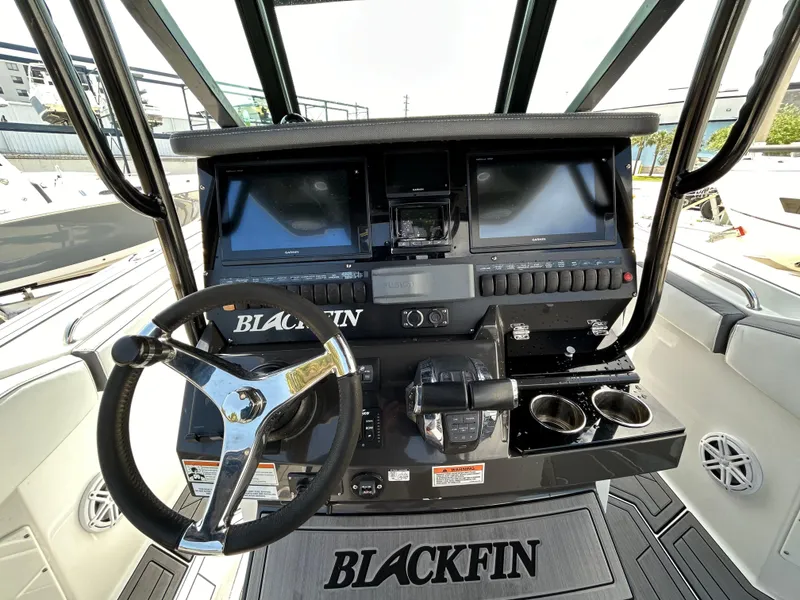 Slide: The Image of 2019 Blackfin 272 CC boat dashboard with steering wheel and dual displays. - 11