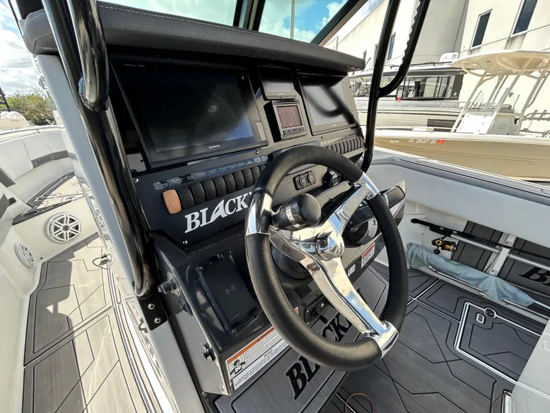 Slide: The Image of 2019 Blackfin 272 CC boat dashboard with steering wheel and controls. - 12