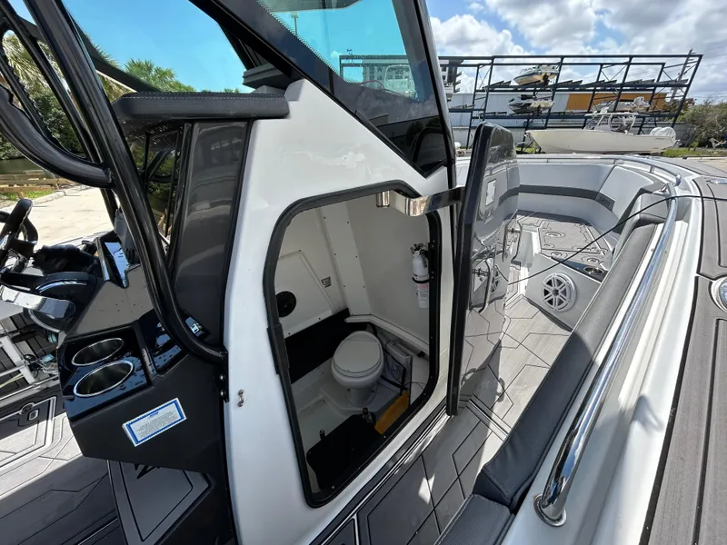 Slide: The Image of 2019 Blackfin 272 CC boat interior with open cabin door and visible toilet. - 16
