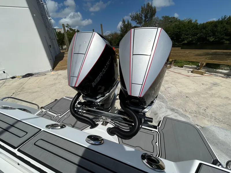 Slide: The Image of 2019 Blackfin 272 CC boat with dual outboard engines, docked under a clear sky. - 2