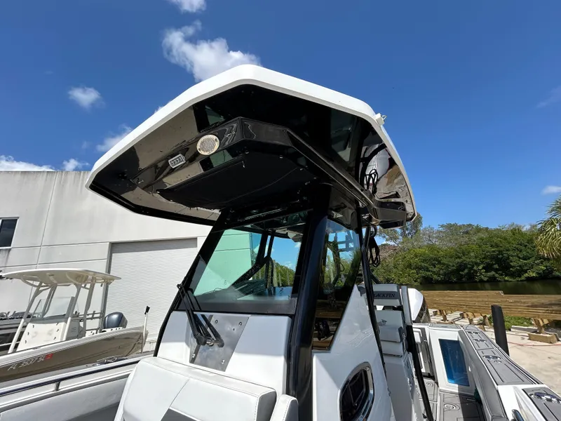 Slide: The Image of 2019 Blackfin 272 CC boat with T-top, docked outdoors under blue sky. - 23