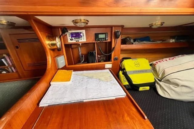 Slide: The Image of Navigation station on 1999 Robinhood Cutter with map, radio, and safety gear. - 15