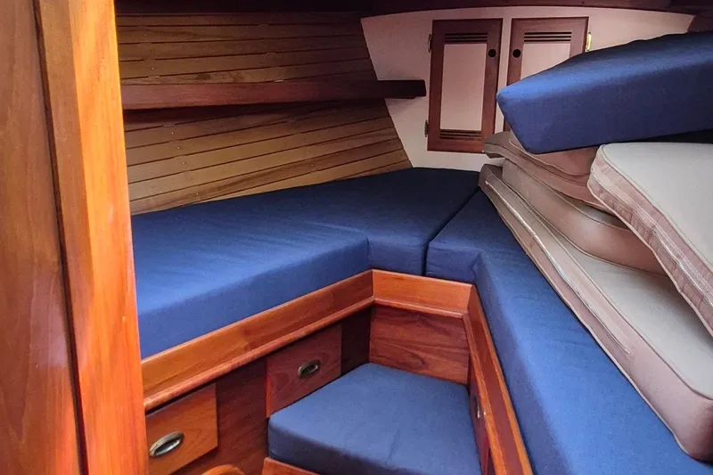 Slide: The Image of Cozy cabin interior of 1999 Robinhood Cutter with blue cushions and wooden storage. - 2