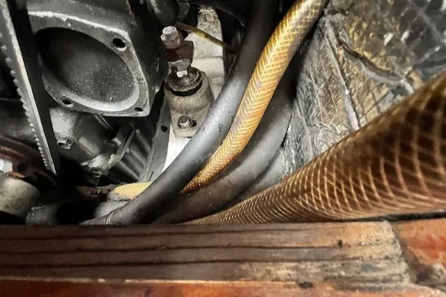 Slide: The Image of Close-up of a 1999 Robinhood Cutter engine compartment with hoses and metal components. - 23