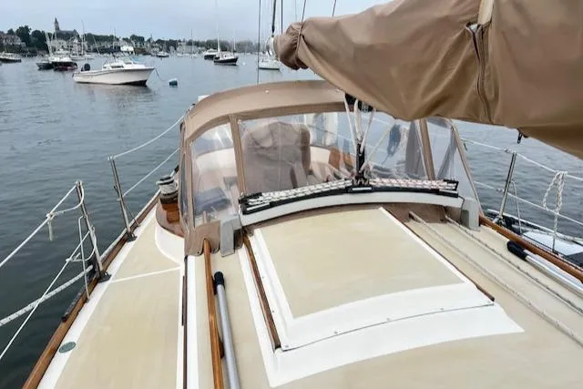 Slide: The Image of 1999 Robinhood Cutter sailboat docked in a marina, featuring a beige deck and canopy. - 29