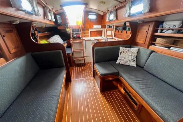 Slide: The Image of Interior of 1999 Robinhood Cutter sailboat with wooden furnishings and cozy seating. - 3