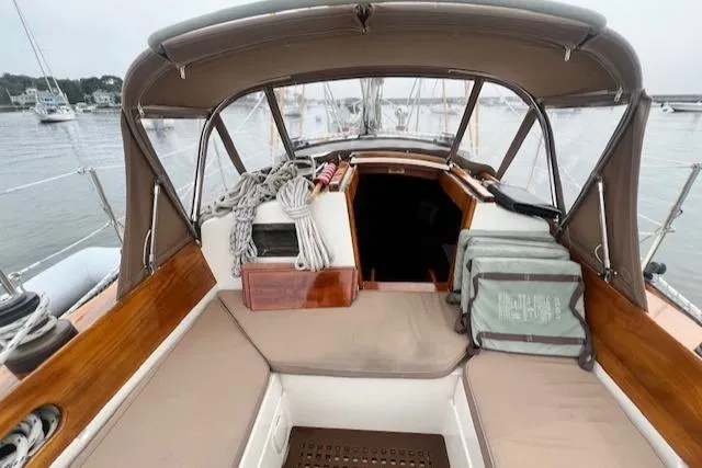 Slide: The Image of 1999 Robinhood Cutter sailboat cockpit with canopy, ropes, and seating, docked in a marina. - 33