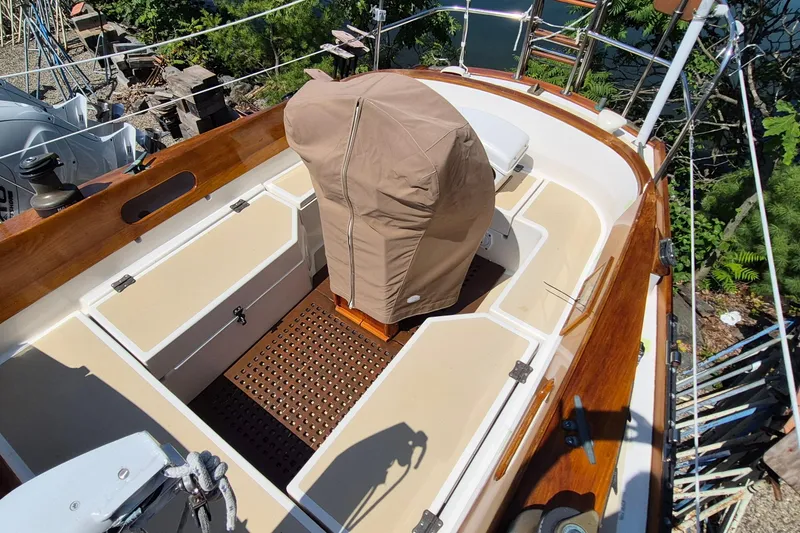 Slide: The Image of 1999 Robinhood Cutter sailboat cockpit with covered helm, wooden trim, and beige seating. - 36