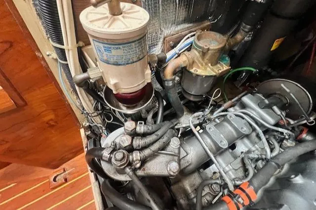 Slide: The Image of Engine compartment of a 1999 Robinhood Cutter sailboat, showcasing mechanical components and wiring. - 42