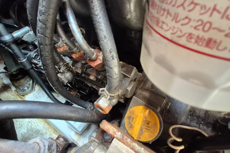 Slide: The Image of Engine components of a 1999 Robinhood Cutter, featuring hoses and oil cap. - 49