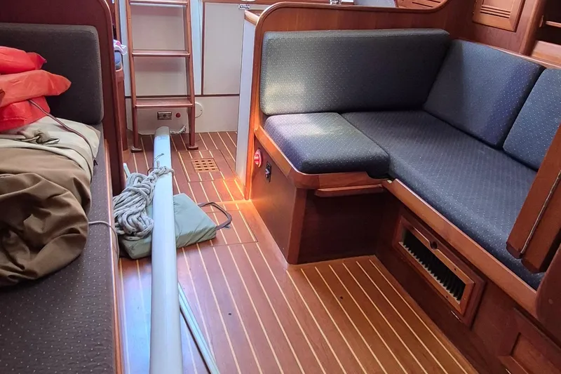 Slide: The Image of Interior of 1999 Robinhood Cutter sailboat with wooden flooring and cushioned seating. - 5