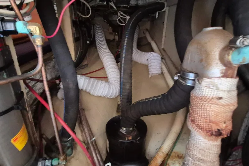 Slide: The Image of Engine compartment of a 1999 Robinhood Cutter with various hoses and pipes. - 50