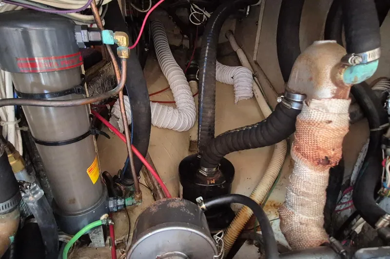 Slide: The Image of Engine room of a 1999 Robinhood Cutter with various hoses and components. - 51