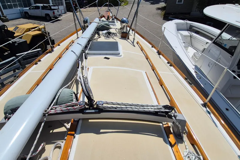 Slide: The Image of 1999 Robinhood Cutter sailboat deck with mast and rigging, docked beside other boats. - 54