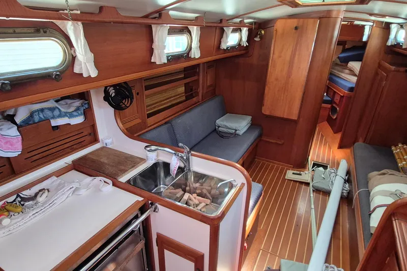 Slide: The Image of Interior of a 1999 Robinhood Cutter sailboat with wooden finishes and cozy seating. - 9