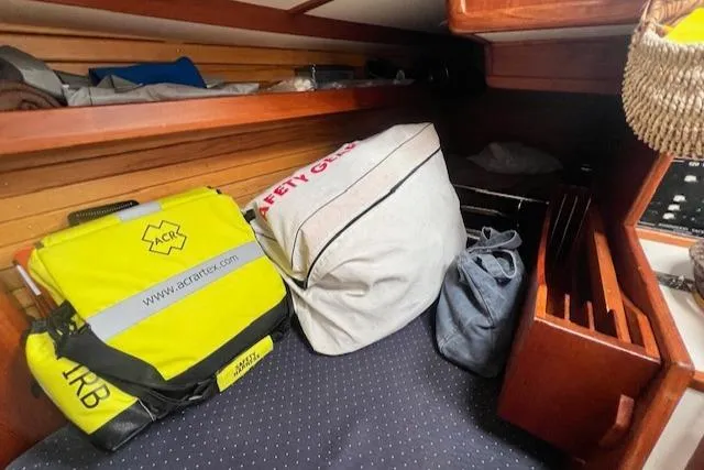 Slide: The Image of Cozy cabin storage with safety gear and bags on a 1999 Robinhood Cutter sailboat. - 20
