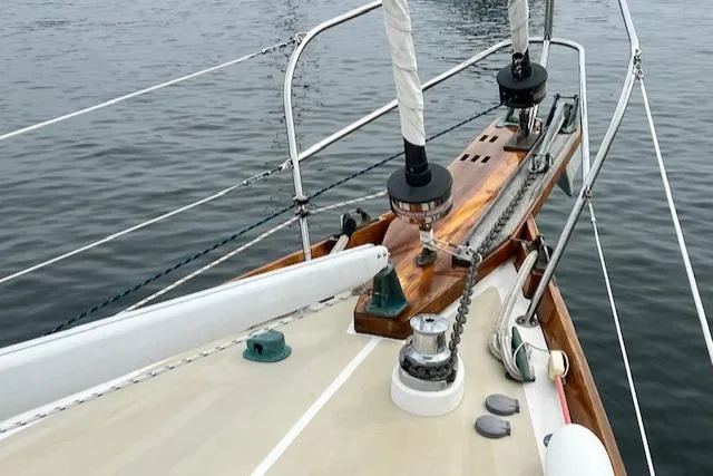 Slide: The Image of Deck view of a 1999 Robinhood Cutter sailboat, featuring rigging and winches. - 26