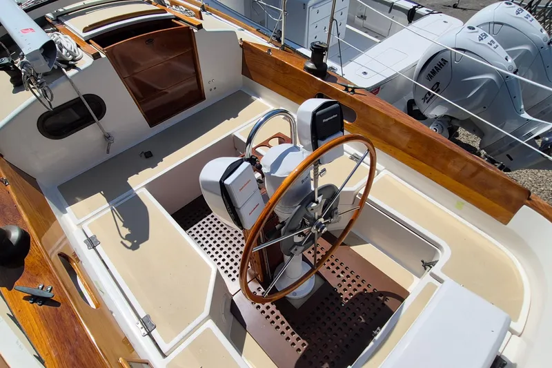 Slide: The Image of 1999 Robinhood Cutter sailboat cockpit with wooden accents and dual steering wheels. - 39