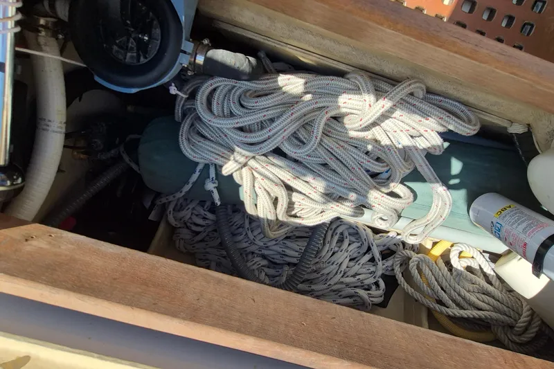 Slide: The Image of Coiled ropes and equipment in a 1999 Robinhood Cutter sailboat storage compartment. - 40