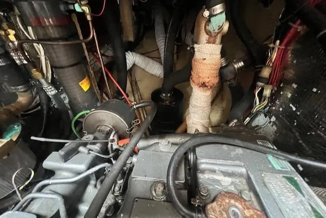 Slide: The Image of Engine compartment of a 1999 Robinhood Cutter sailboat, showcasing various mechanical components and wiring. - 43