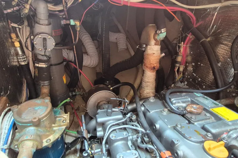 Slide: The Image of Engine compartment of a 1999 Robinhood Cutter sailboat, showcasing mechanical components and wiring. - 45