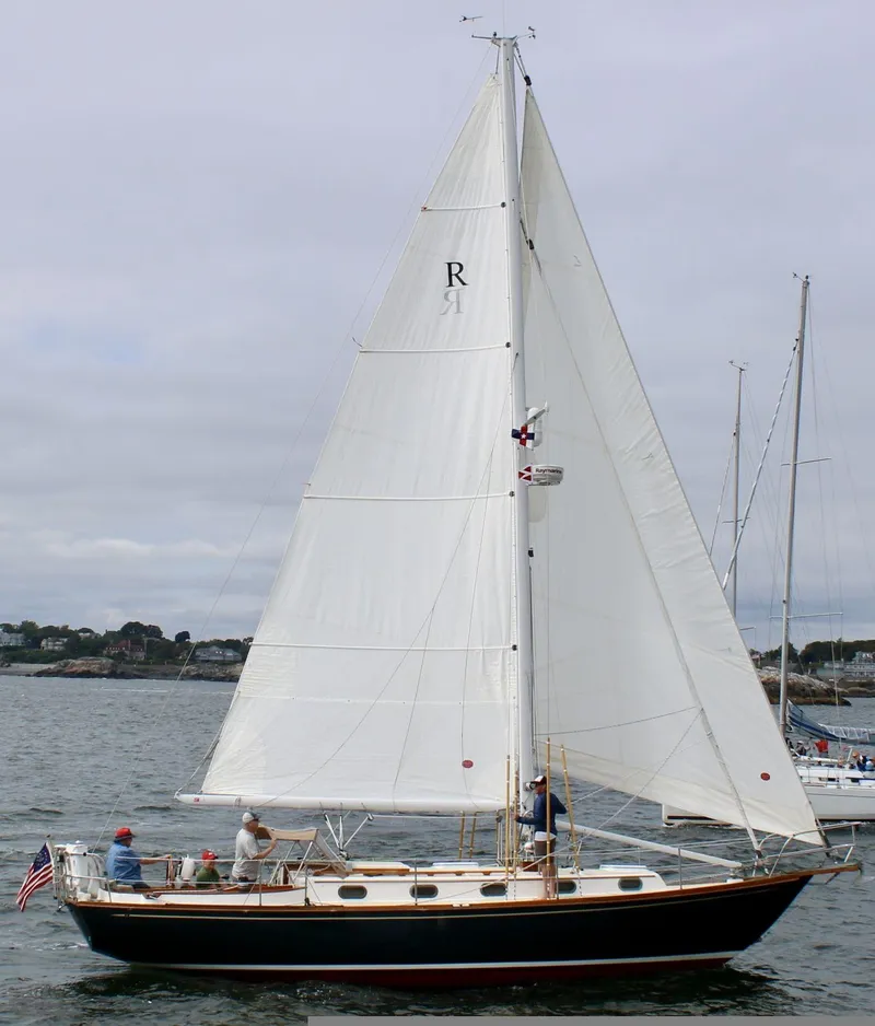 Slide: The Image of Sailboat on water, Robinhood Cutter 1999, with white sails and American flag. - 60