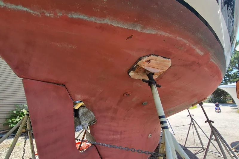 Slide: The Image of Red hull of a 1999 Robinhood Cutter sailboat on stands for maintenance. - 63