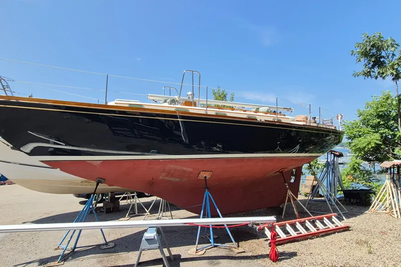Slide: The Image of 1999 Robinhood Cutter sailboat on stands, undergoing maintenance, with clear blue sky background. - 64