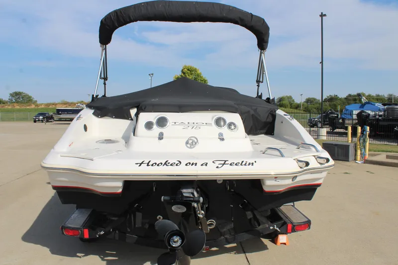 Slide: The Image of 2015 Tahoe 215 I/O boat with "Hooked on a Feelin'" text, parked outdoors. - 6