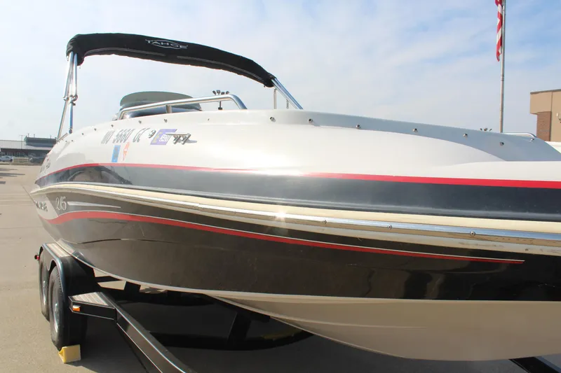 Slide: The Image of 2015 Tahoe 215 I/O boat on trailer, sleek design, black and white with red accents. - 8