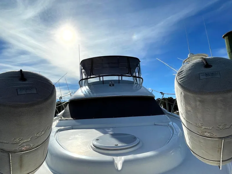 Slide: The Image of 2006 Silverton 39 Motor Yacht under a bright blue sky with sun. - 12