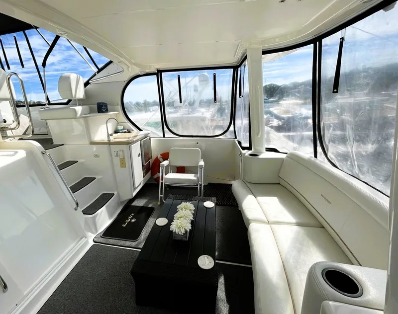 Slide: The Image of 2006 Silverton 39 Motor Yacht interior with white seating, table, and panoramic windows. - 19