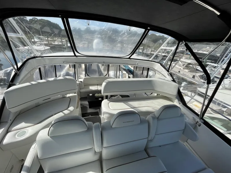 Slide: The Image of 2006 Silverton 39 Motor Yacht interior with white seating and marina view. - 21