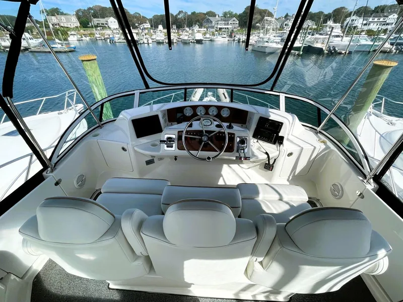 Slide: The Image of 2006 Silverton 39 Motor Yacht helm with white seating, overlooking marina. - 22