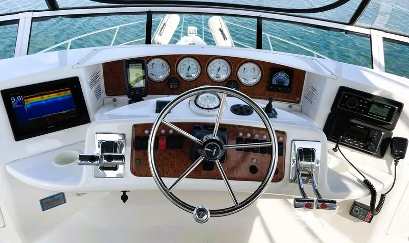 Slide: The Image of 2006 Silverton 39 Motor Yacht helm with steering wheel, gauges, and navigation equipment. - 27